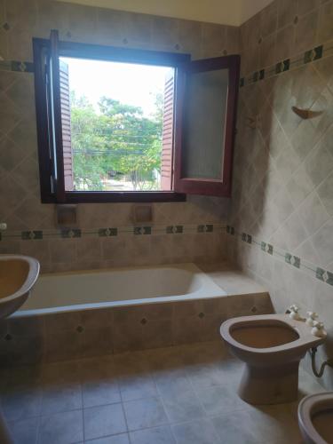 baño con bañera, aseo y ventana en Garden dream en San Salvador de Jujuy