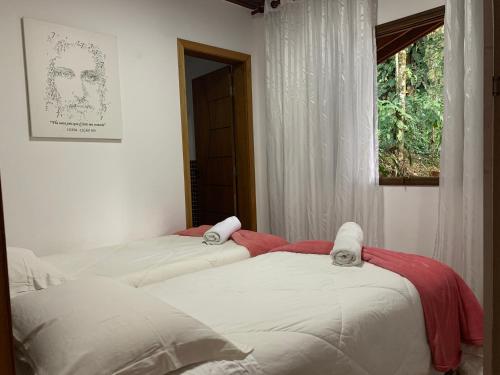 2 camas en una habitación con ventana en Casa Oásis: Requinte, Paz e Conforto na Natureza, en Atibaia