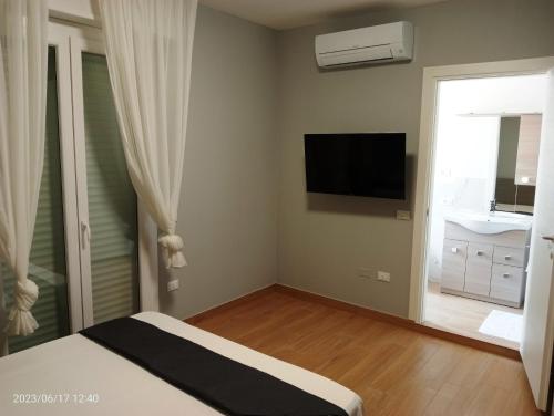 a bedroom with a bed and a flat screen tv at Residenza delle Nazioni in Gatteo a Mare