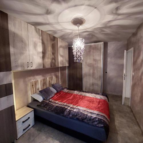 um quarto com uma cama e um lustre em Apartman Irena em Loznica