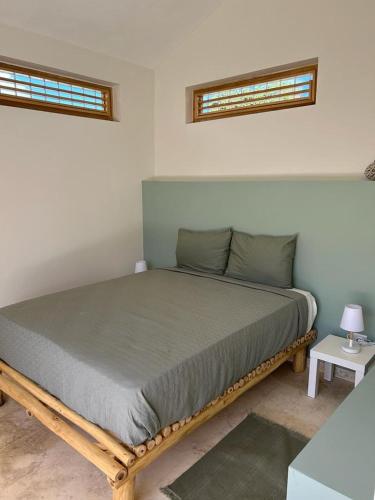 łóżko w pokoju z 2 oknami w obiekcie Casita Cayena w mieście Las Galeras