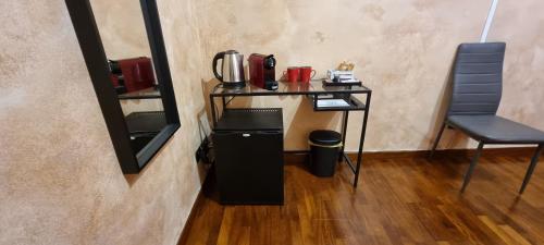 a table with a coffee maker and a chair in a room at Wanderlust Pietralata B&B in Rome