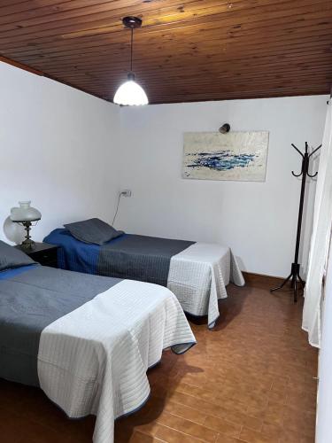a bedroom with two beds and a wooden ceiling at La casa de Ana in Alberti