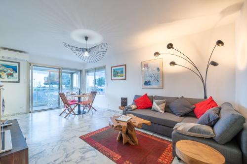 a living room with a couch and a table at Magnifique 2 pièces vue mer - Parking Proche plage in Saint-Laurent-du-Var
