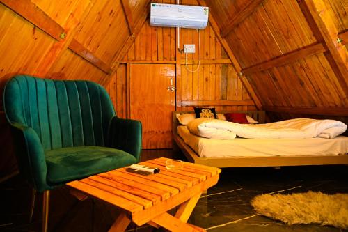 a room with a bed and a chair and a table at cebos tranquil in Hyderabad