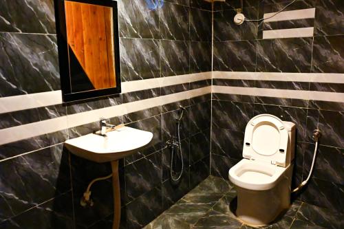 a bathroom with a toilet and a sink at cebos tranquil in Hyderabad