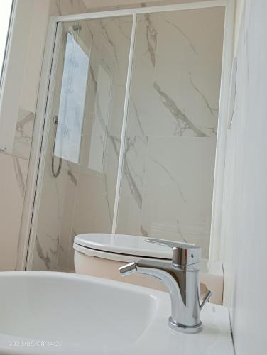 a white bathroom with a toilet and a sink at Residenza delle Nazioni in Gatteo a Mare