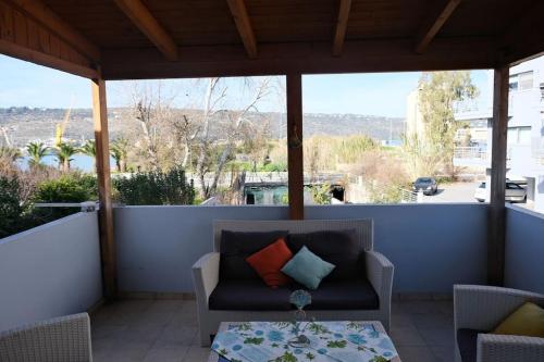 a screened in porch with a couch and a table at Bayside Apt. in Souda