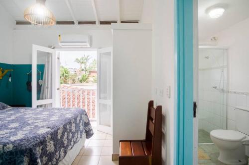 a bedroom with a bed and a bathroom with a toilet at Chalé Aconchegante na Praia da Tabatinga in Caraguatatuba