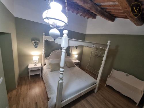 1 dormitorio con cama blanca y lámpara de araña en Vesionica Holiday House, en Civitella Benazzone