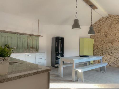 a kitchen with a table and a refrigerator at Casa do Caseiro in Outeiro Maior