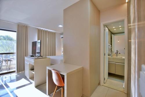 um quarto com uma secretária, um lavatório e um espelho em Belíssimo Flat no Lake Side - Beira Lago em Brasília