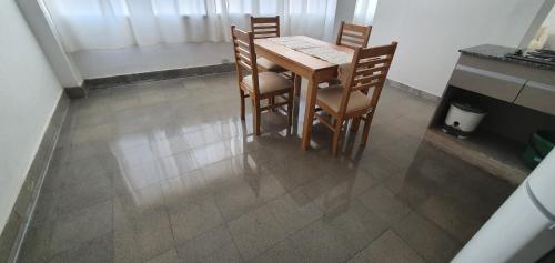 een tafel en stoelen in een kamer met een tegelvloer bij Castelo Natura Apartments Sarmiento a 30 mts de la Catedral in San Fernando del Valle de Catamarca