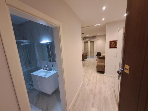 a bathroom with a white sink and a mirror at Apartment Cathedral Square in Shkodër
