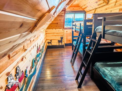 a bedroom with bunk beds in a log cabin at Modern Luxury-6 Bed 5 Bath CABIN AMAZING LOCATION & PRIVACY! -4 Miles to Gatlinburg-7 to Dollywood-Hot Tub-Fireplace-King Suits-Theater-Grill-Free Parking for 10 Vehicles-Fire pit-Fully Stocked Kitchen-"Smoky View Cabin" in Sevierville