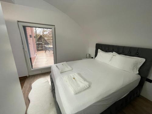 1 dormitorio con 1 cama blanca grande y ventana en Bellevue, en Orllan