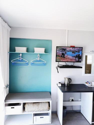 a room with a desk and a blue wall at Langebaan Beach Towers in Langebaan
