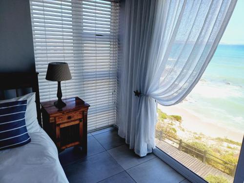 a bedroom with a window with a view of the ocean at Langebaan Beach Towers in Langebaan