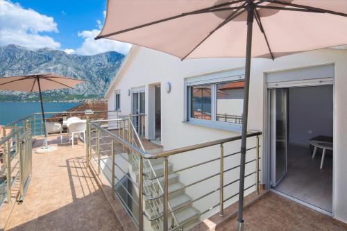 a balcony with an umbrella and a view of the water at Apartments Bonaca in Kotor