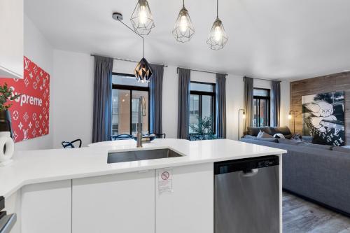 eine Küche mit Spüle und ein Wohnzimmer in der Unterkunft LiV MTL Urban in Montreal