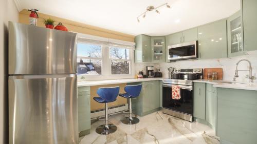 バレー・ストリームにあるThe Mod Pad! 15 min from Airport, Free Parking!のキッチン(緑のキャビネット、青いスツール付)