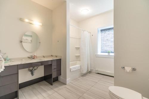 a bathroom with a sink and a toilet and a mirror at Spacious & Stylish Apt #1 with AC in Halifax