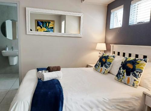 a bedroom with a bed with a mirror and a sink at Langebaan Beach Towers in Langebaan