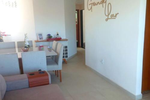 a living room with a table and a dining room at Apart° Grande Lar in Guarapari
