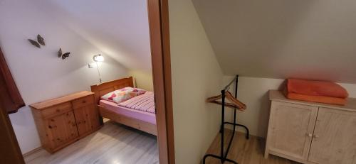 a small room with a bed and a lamp in it at Apartments & Hostel Bohinj in Bohinj