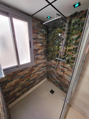 een badkamer met een douche en een bakstenen muur bij VALLFOGONA Relax in Santa Bárbara