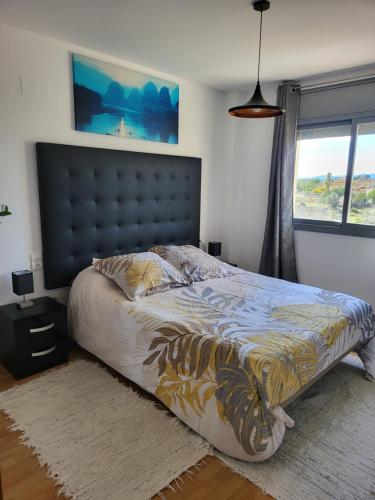 een slaapkamer met een groot bed en een groot raam bij VALLFOGONA Relax in Santa Bárbara