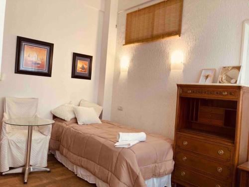 a small bedroom with a bed and a dresser at Buenos Aires Apartment in Buenos Aires