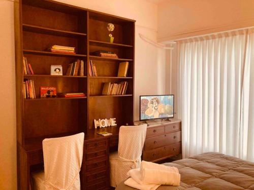 Schlafzimmer mit Bücherregal und Bett in der Unterkunft Buenos Aires Apartment in Buenos Aires