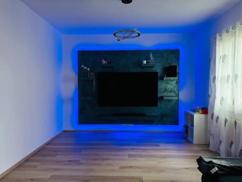 Sala de estar azul con TV de pantalla grande en Nido di tranquillità, en San Mauro Pascoli