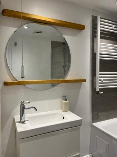 a bathroom with a sink and a mirror at Lofty split-level period flat in Highbury in London