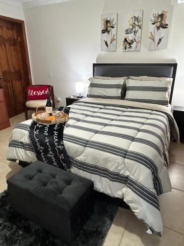 a bedroom with a large bed with a black ottoman at Paradise in Miami