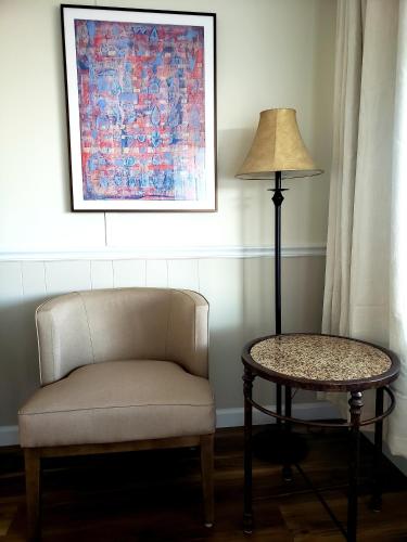 a chair and a lamp in a room with a table at Blue Vista Motor Lodge in Florida