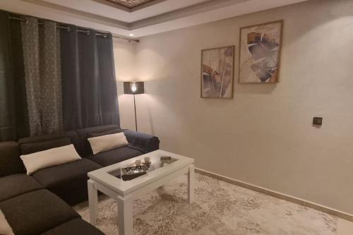 een woonkamer met een bank en een tafel bij Appart familial chic & confort in Kenitra