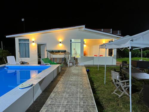 une maison blanche avec une piscine la nuit dans l'établissement Casa de Playa - Cerro Azul, à Cerro Azul