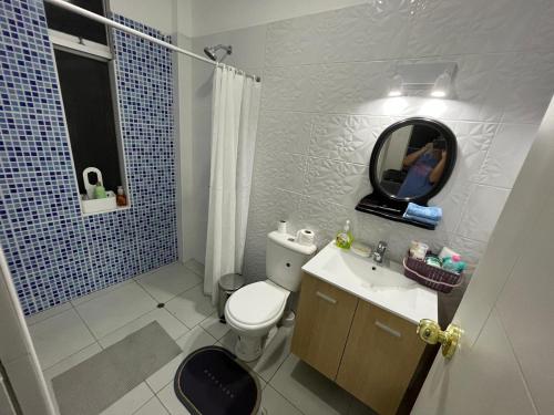 La salle de bains est pourvue de toilettes, d'un lavabo et d'un miroir. dans l'établissement Casa de Playa - Cerro Azul, à Cerro Azul