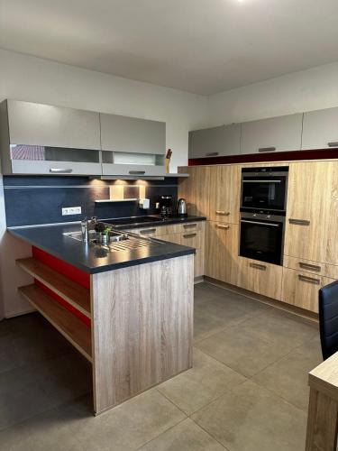eine Küche mit Holzschränken und einer schwarzen Arbeitsplatte in der Unterkunft Ferienhaus am Glück in Bad Zwischenahn