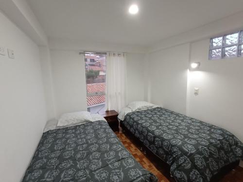 1 Schlafzimmer mit 2 Betten und einem Fenster in der Unterkunft II - Zaguan Aparta Hotel Cusco in Cusco
