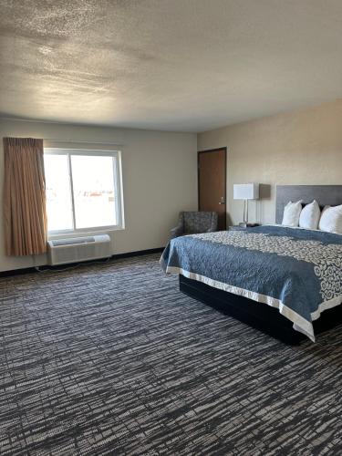 a hotel room with a bed and a window at Super 8 by Wyndham Grand Island in Grand Island