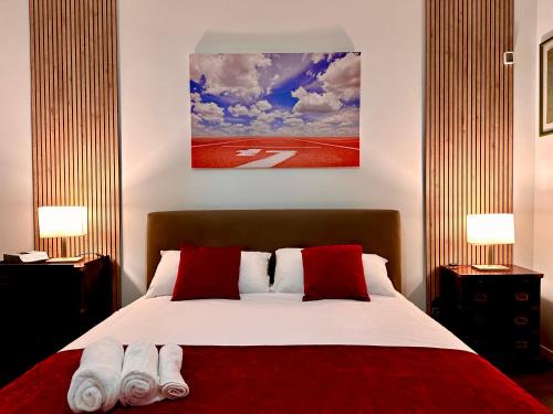 1 dormitorio con 1 cama grande con almohadas rojas en Villa Brando - Luxury Stay near Sabaudia and Pontine Beaches en Latina
