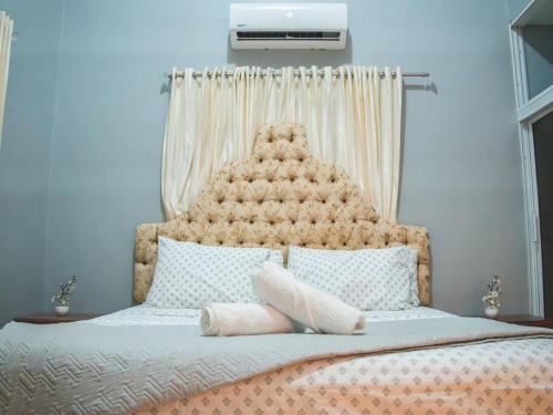 uma cama grande com uma grande cabeceira num quarto em Welcome to Villa D’Mirella! em Santiago de los Caballeros