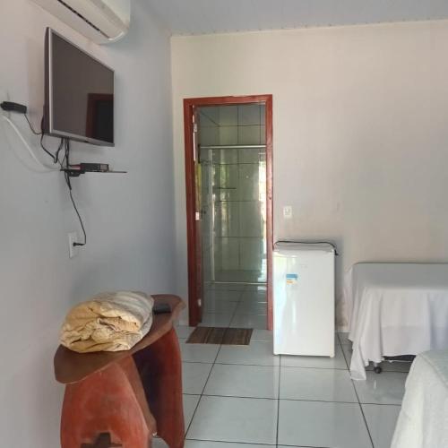 een kamer met een televisie, een tafel en een deur bij Pousada e restaurante Jardim do Cerrado in Nobres