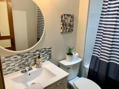 een badkamer met een wastafel, een toilet en een spiegel bij Quiet Studio #1 in Halifax