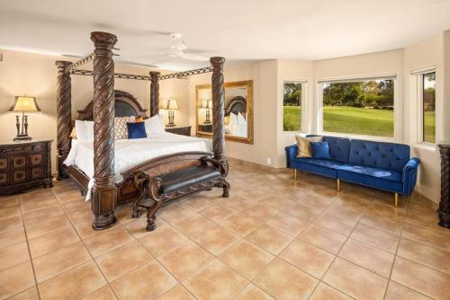 1 dormitorio con cama con dosel y sofá azul en Ethereal Corner Ritz Carlton Grand Estate Golf Mountains Jacuzzi Sauna Theater Gym, en Scottsdale