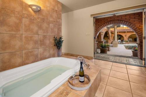 a bathroom with a bath tub with a bottle of wine at Ethereal Corner Ritz Carlton Grand Estate Golf Mountains Jacuzzi Sauna Theater Gym in Scottsdale