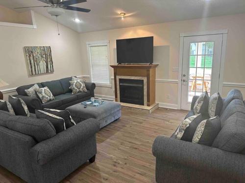a living room with two couches and a flat screen tv at Bears Valley Inn - Less than 15 Min to Attractions - Great Mtn Views - Private Pool Club - EZ Access Roads - Luv Dogs! in Sevierville